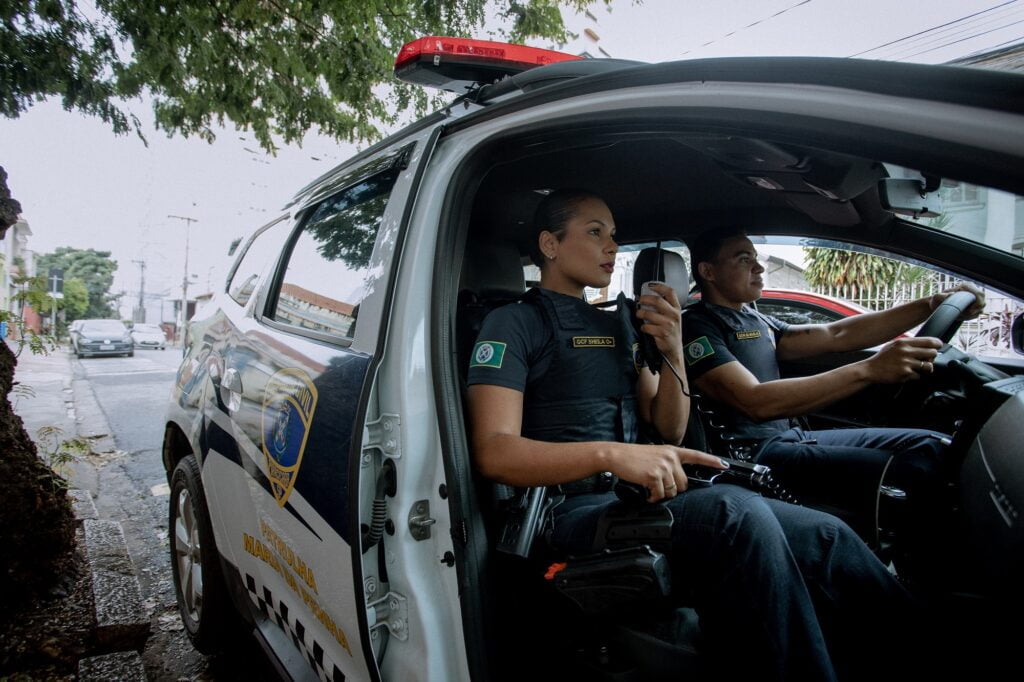 Guarda Civil sentada em viatura, ao lado de homem, guarda civil