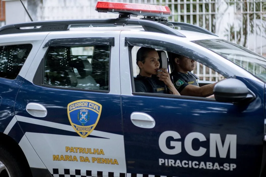 Viatura azul da Guarda Civil com uma guarda feminina e outro masculino