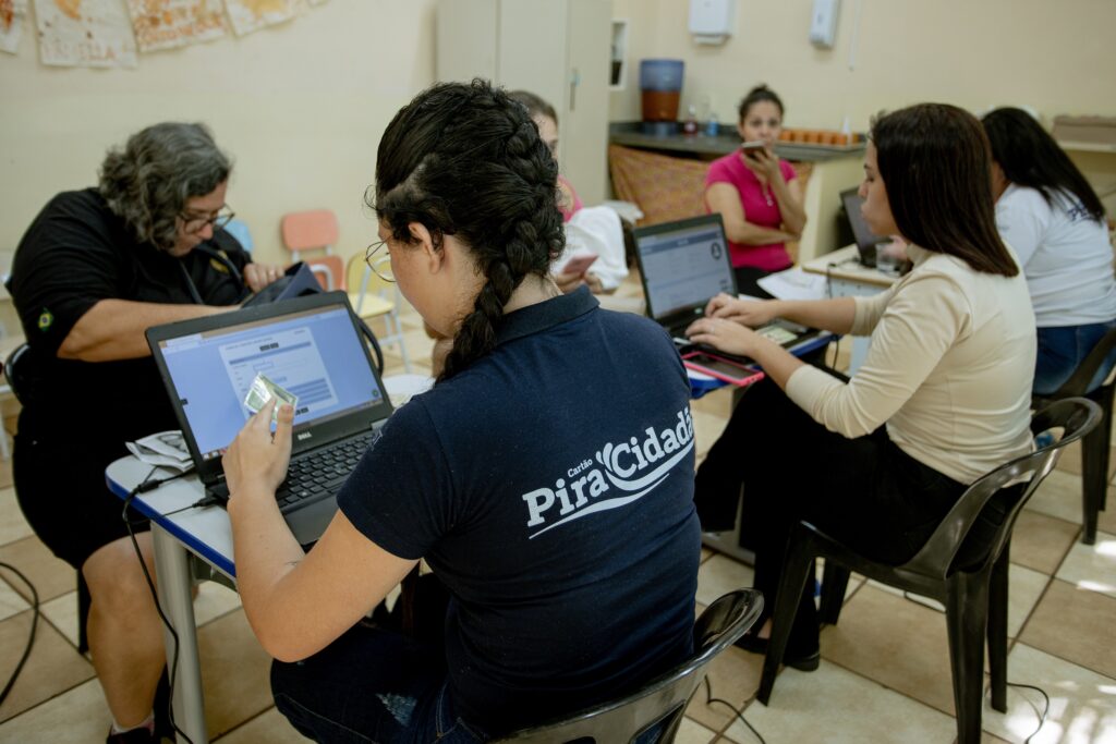 foto colorida mostra duas atendentes sentadas em frente ao computador onde fazer o cadastramento de pacientes da rede publica de saúde