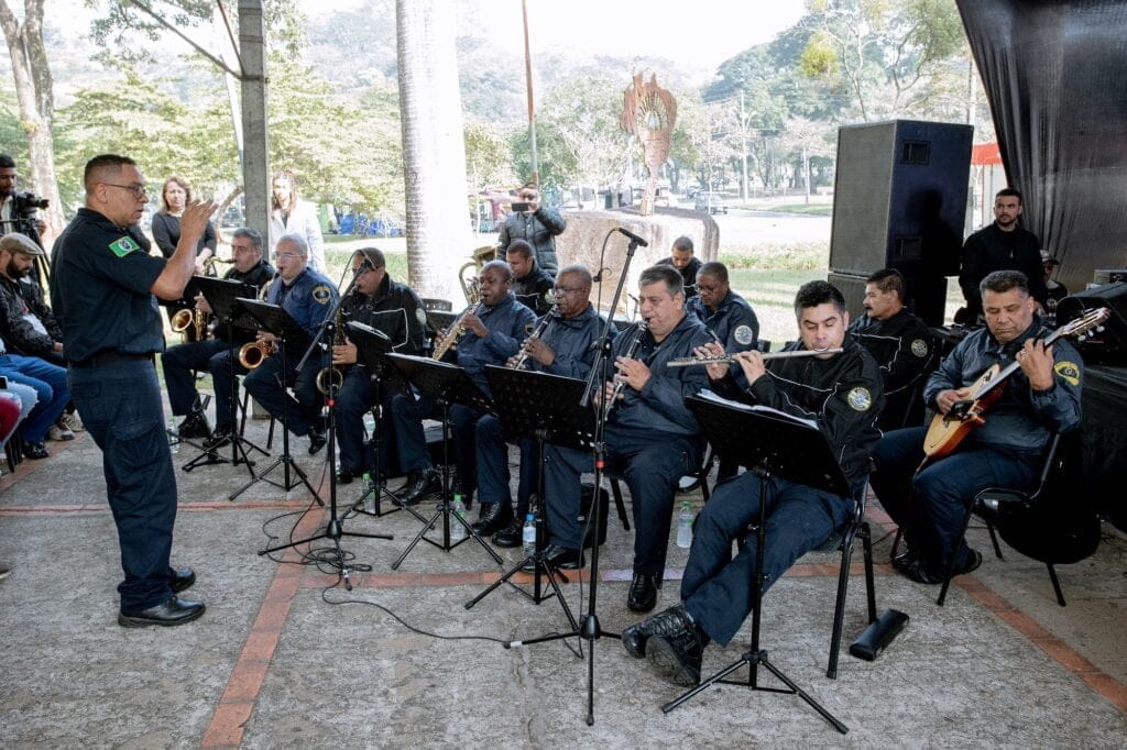 Componentes da Banda da Guarda Civil de uniforme escuro com instrumentos