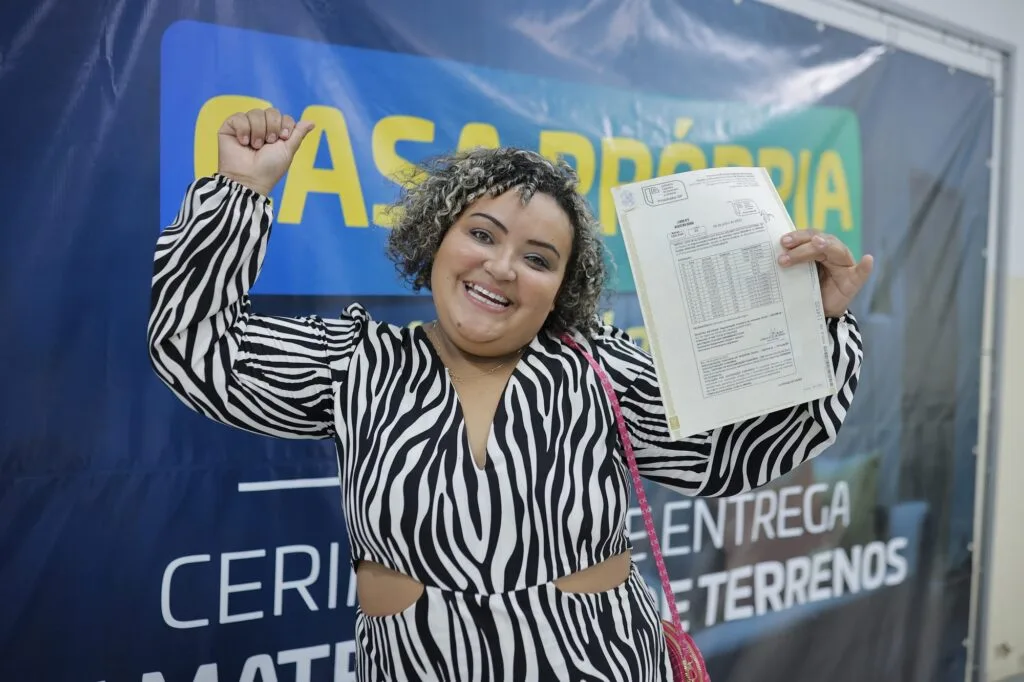 Mulher com os braços para cima, celebrando a entrega do documento