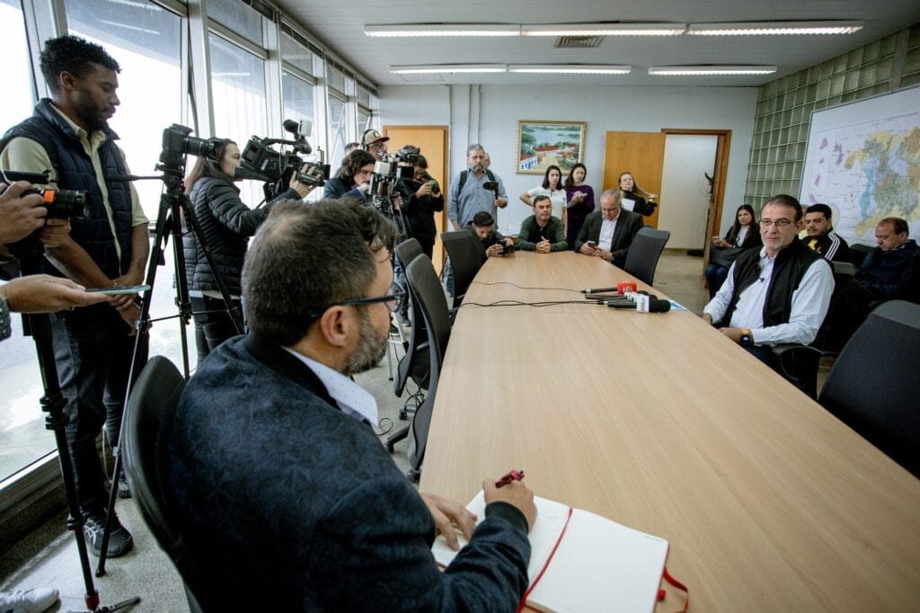 Prefeito de Piracicaba de blusa no centro da mesa 