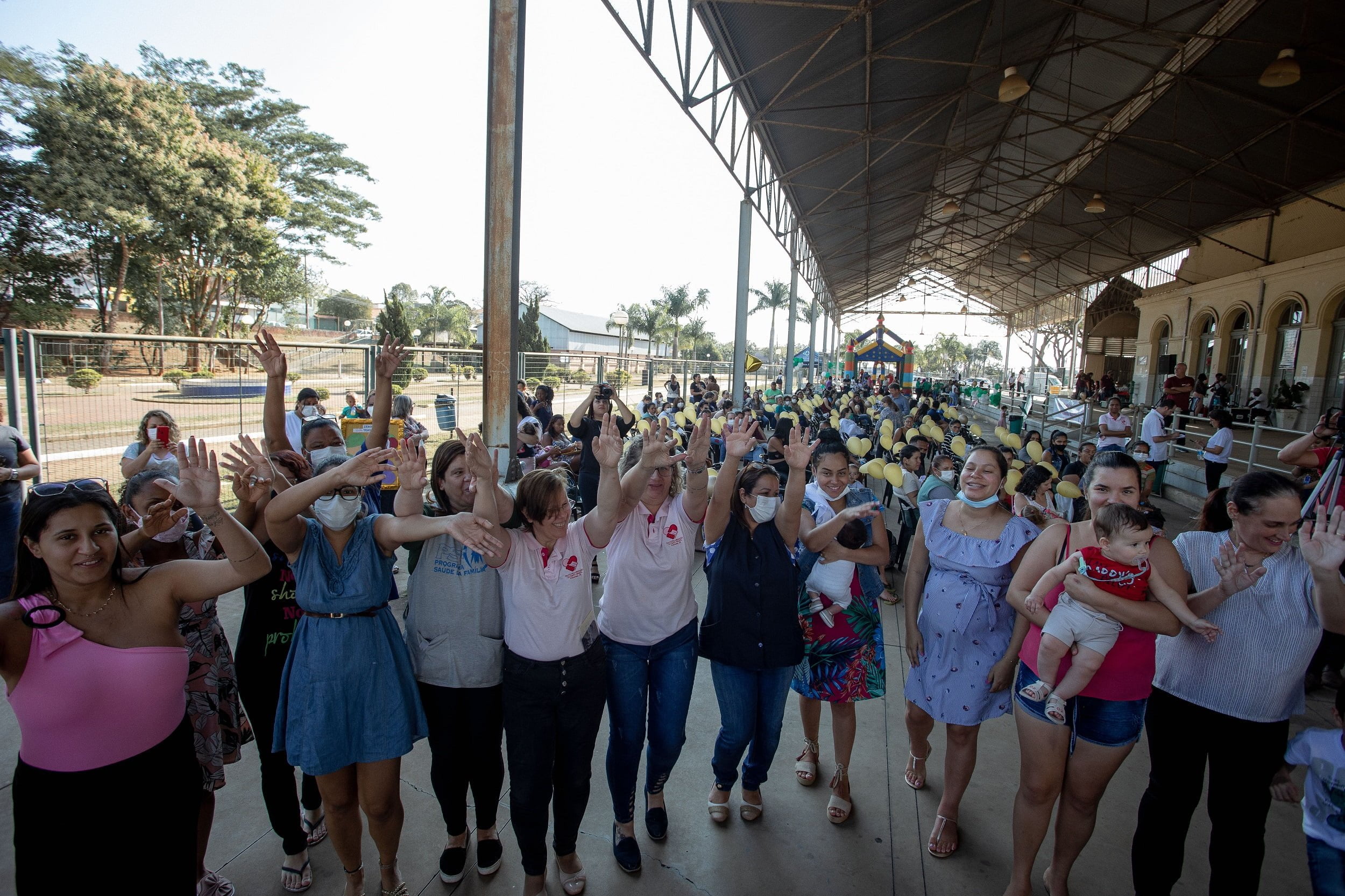 Centenas de mulheres participaram de dança materna realizada pela prefeitura. na imagem, cerca de 30 pessoas, estão de mãos dadas e balançam as mãos no ritmo musical apresentado