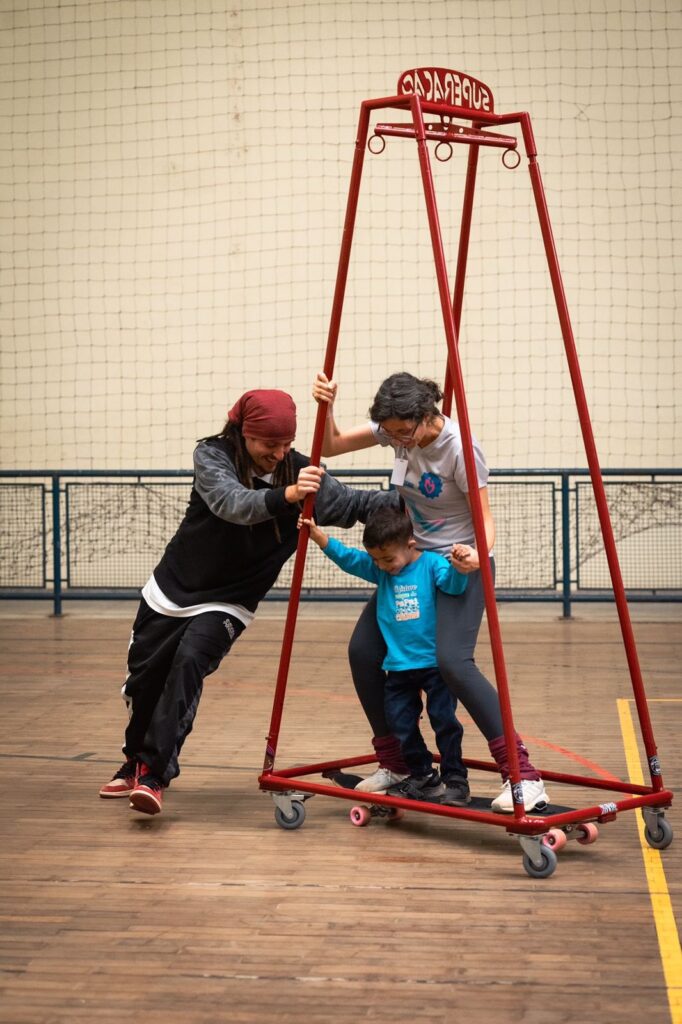 Imagem de criança e adulto utilizando o skate inclusivo