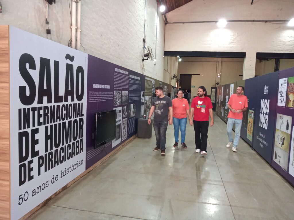Imagem da Equipe do Salão de Humor durante último dia da montagem percorrendo por entre o corredor da exposição