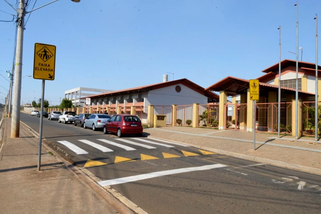 carros estacionados em fileira, perto da faixa de pedestre branca