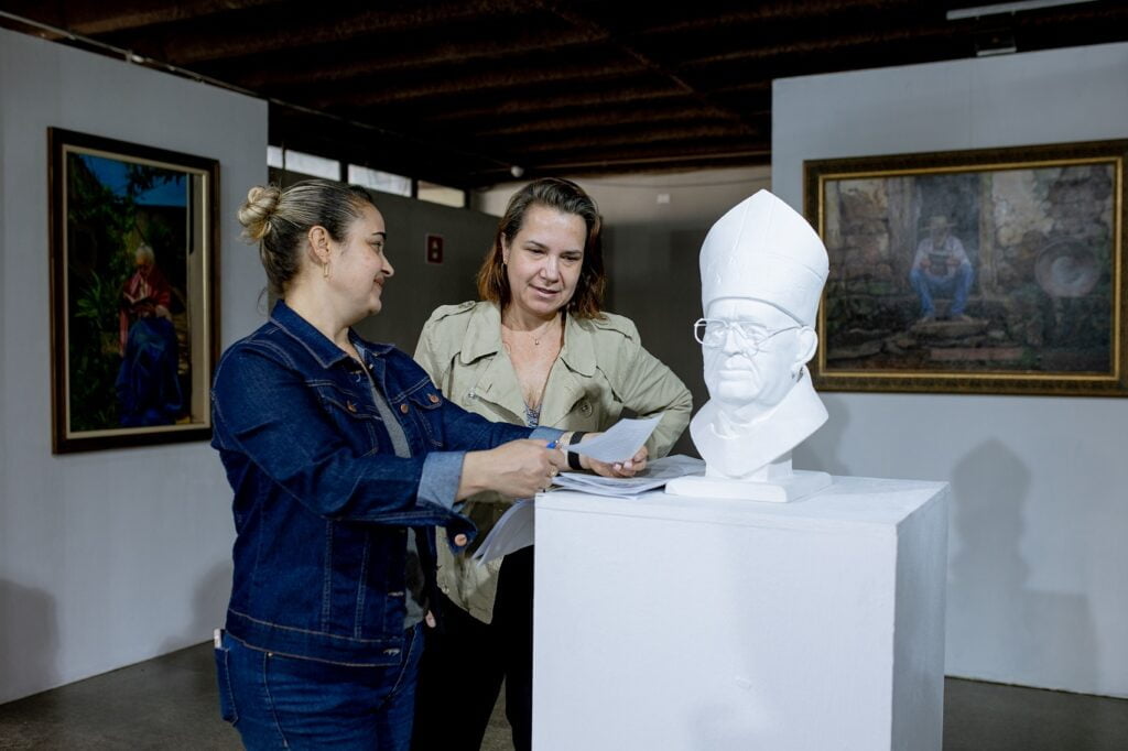 Juliana Mazzero e Renata Gava e o busto, em gesso, de Don Diórgenes