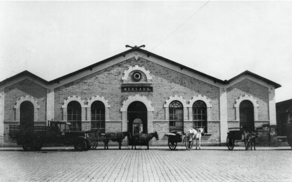 Imagem do prédio antigo do Mercado Municipal de Piracicaba, com carroças paradas na frente