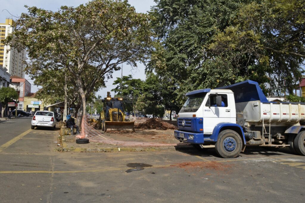 Imagem de caminhão e trator em serviço para a remodelação de praça da cidade