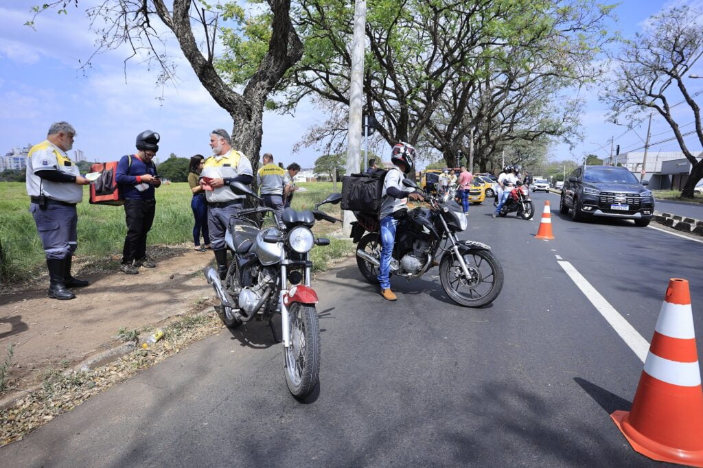 Imagem de carros e motos em avenida de Piracicaba, com profissionais da secretaria de trânsito fiscalizando os veículos