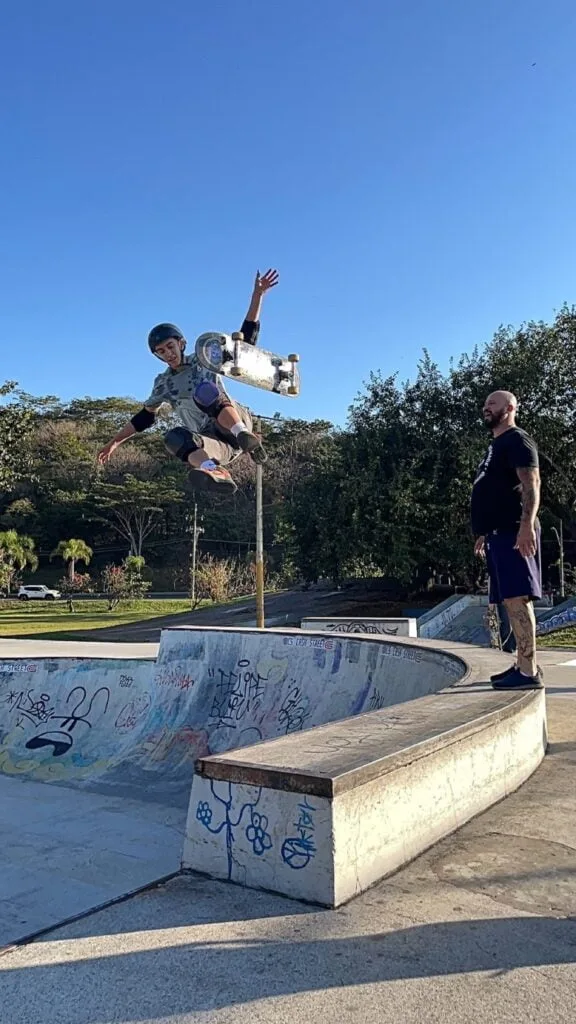 skatista de capacete realizando manobra,saltando alto