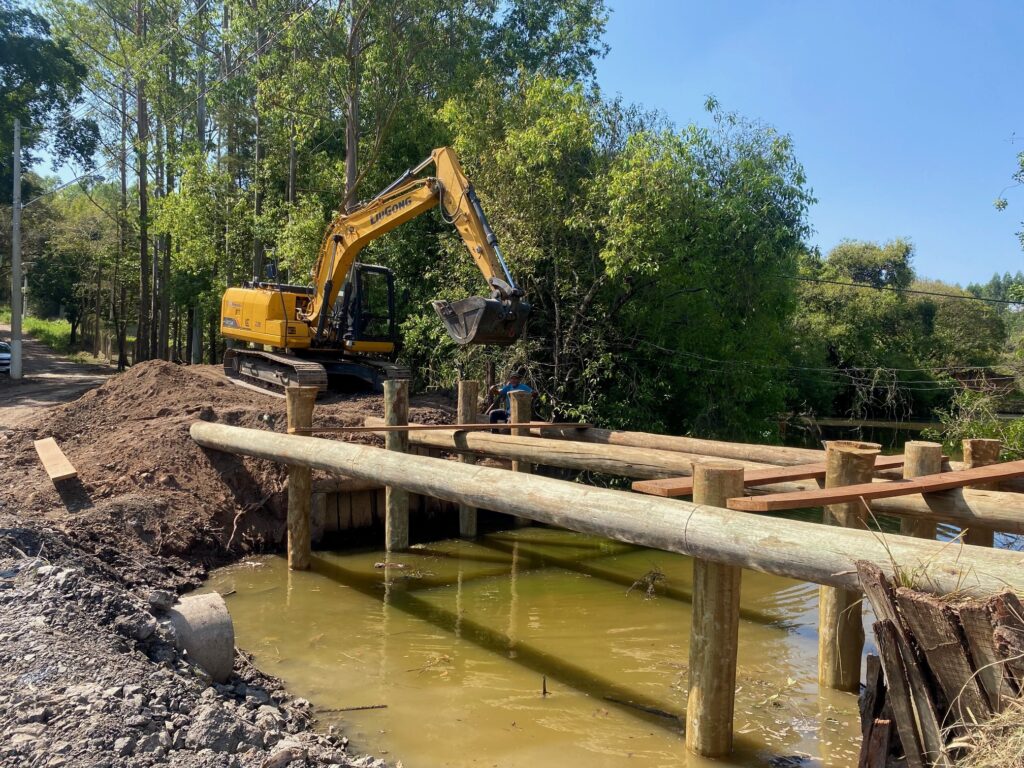 Escavadeira da Sema fazendo a reconstrução da ponte com madeiras de eucalipto tratado