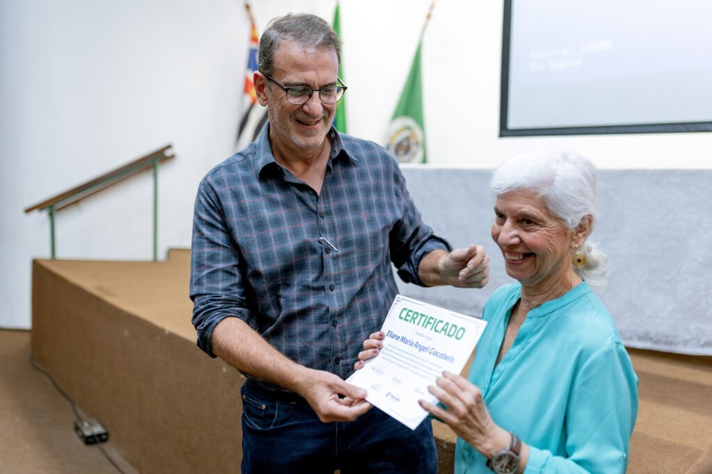 Imagem de duas pessoas, sendo elas: Prefeito Luciano Almeira entregando o certificado para Eliane Giacobelis