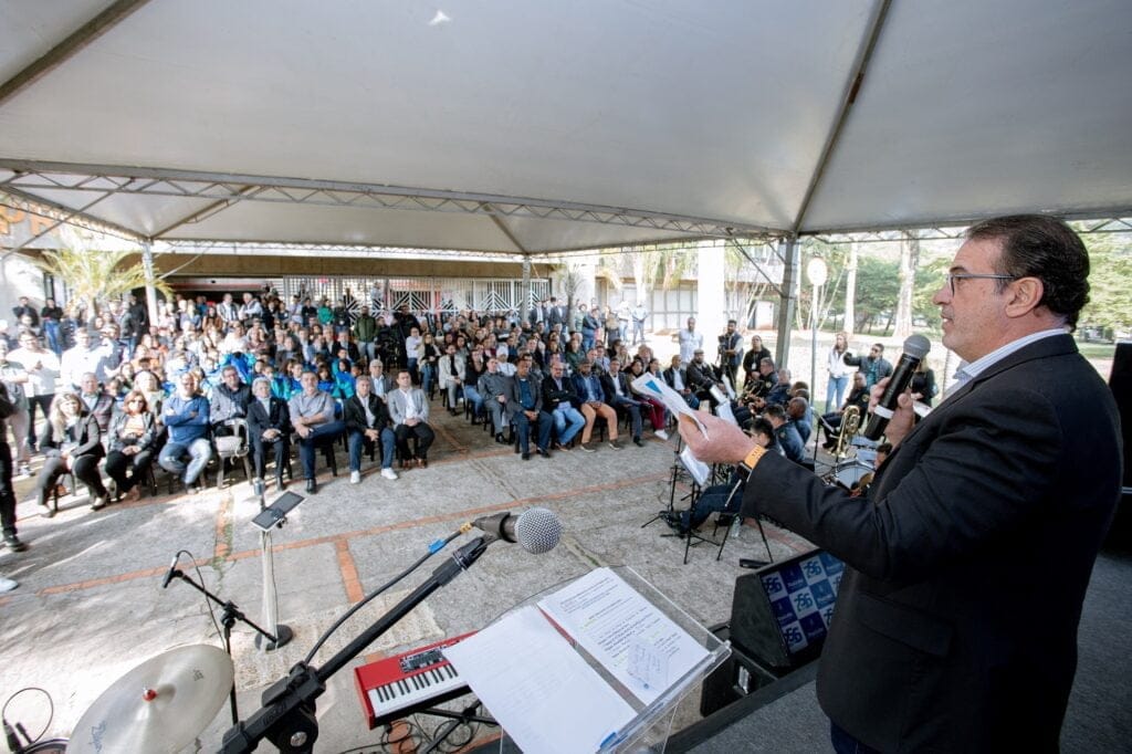 Prefeito de Piracicaba segura papel branco e fala ao microfone