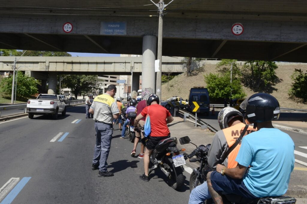 imagem de homens e motos paradas em avenida