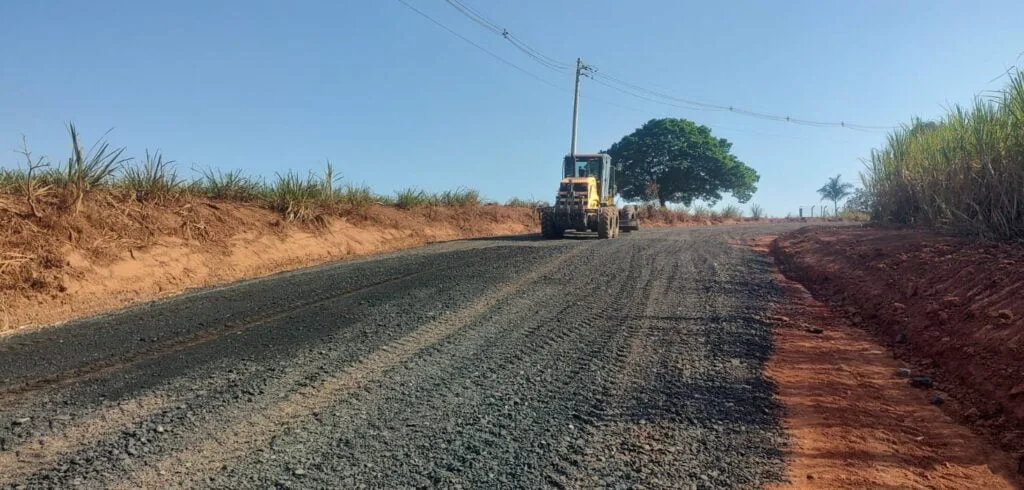 Imagem de uma máquina passando pela estrada, com as raspas de asfalto já aplicadas