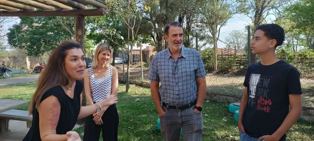 Grupo de pessoa conversa na entrada da escola estadual.