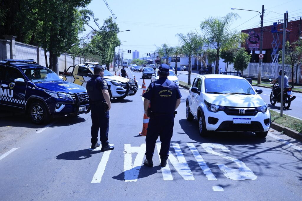 homens em pé e carros passando na rua
