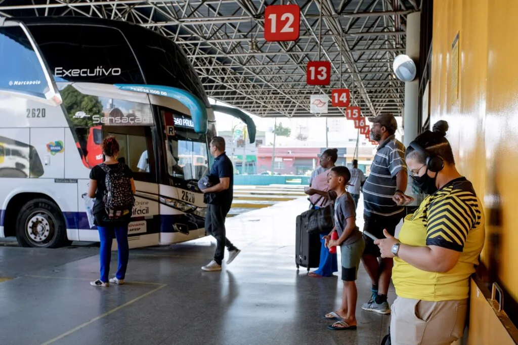 Imagem de pessoas em fila aguardando ônibus