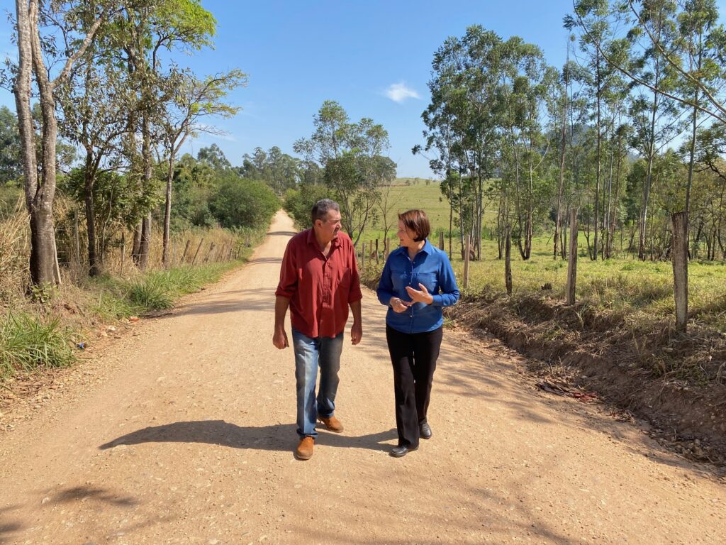 Produtor rural Noedir Granja e secretária Nancy Thame caminhando na estrada do bairro Floresta, após manutenção feita pela Sema