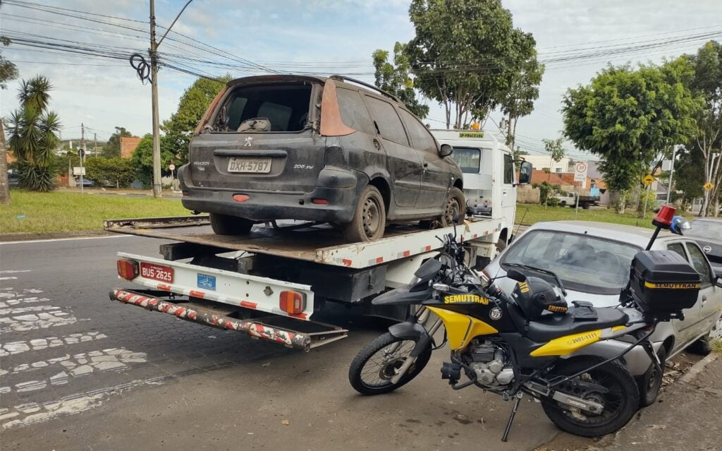 Imagem de carro em cima de caminhão e moto em destaque na frente