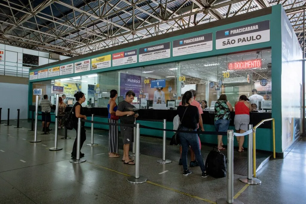 Imagem com guichês de venda de passagens de ônibus com pessoas filas