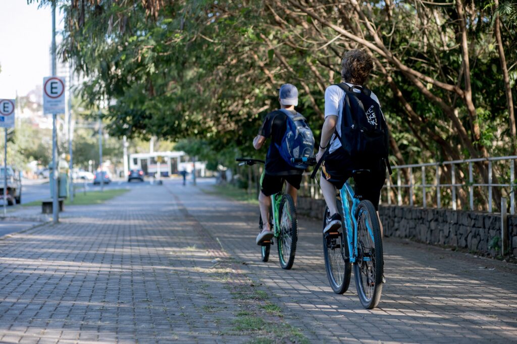 dois ciclistas pedalando em avenida