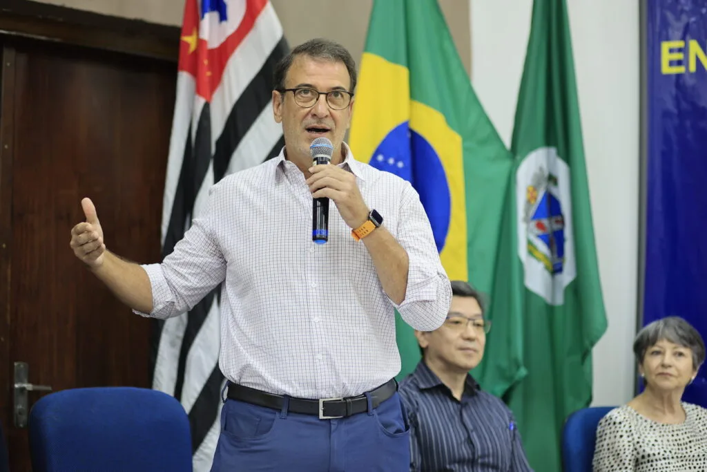 no palco da Fumep, prefeito Luciano Almeida fala para o público ao lado de autoridades como o médico Douglas Koga e a diretora do Cerest Clarice Bragantini