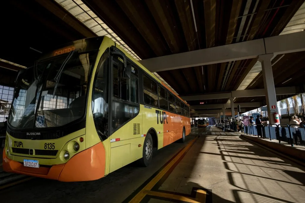Onibus na cor amarela e laranja, estacionado no Terminal Central de Integração (TCI).