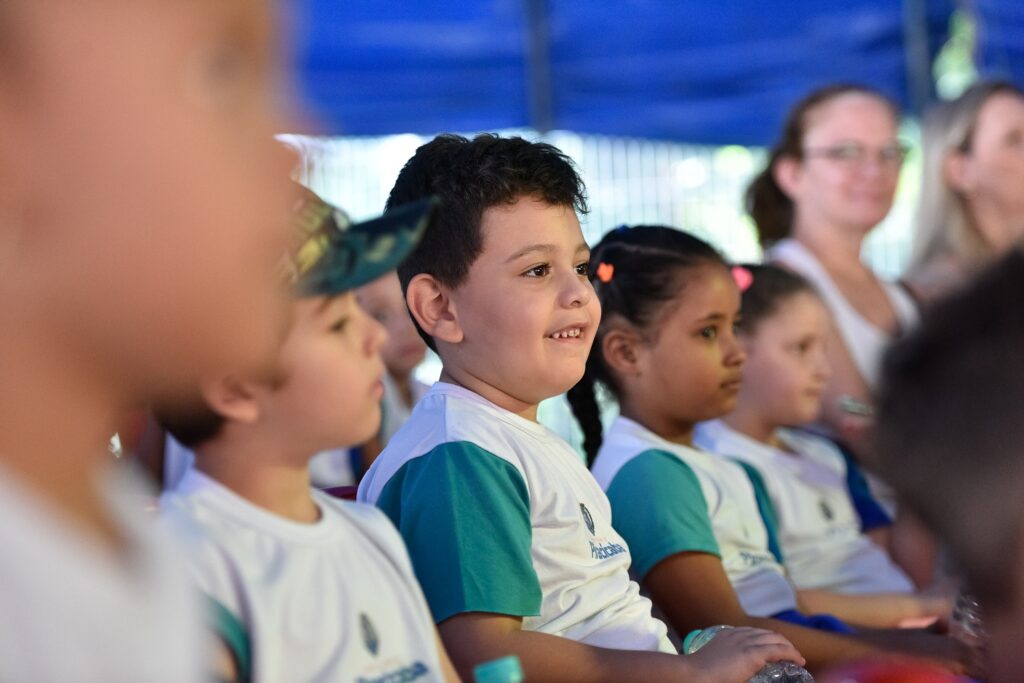 Crianças de escolas municipais assistem sorridentes a espetáculo na lona Pimentinha