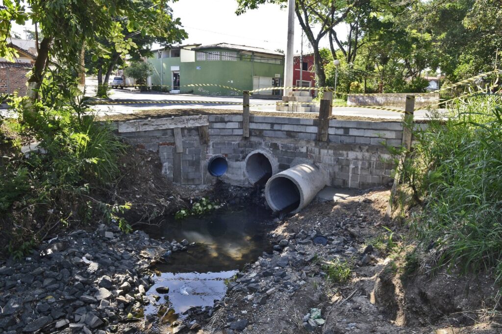 Córrego com tubos brancos.