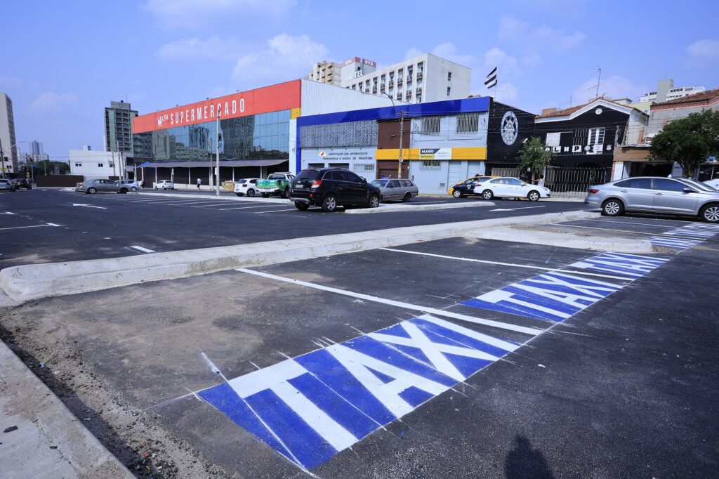 Sinalização de piso com letras taxi em azul.
