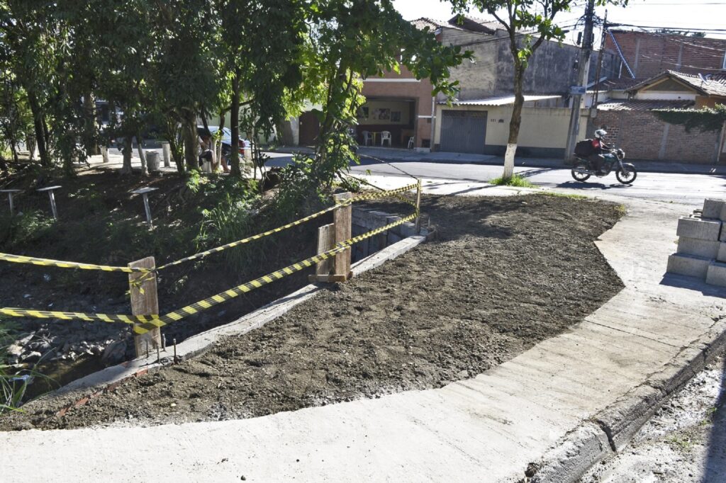 Córrego cercado por fitas amarelas.