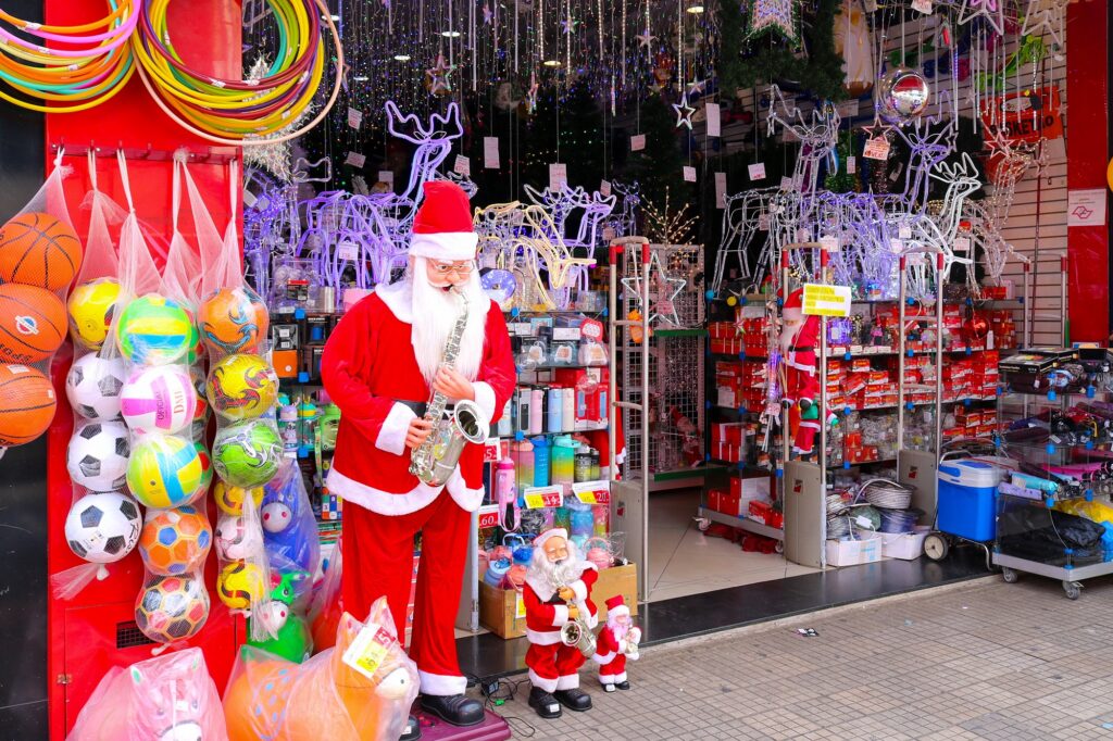 Boneco do Papai Noel, com roupas nas cores vermelho e branco, em frente a loja.