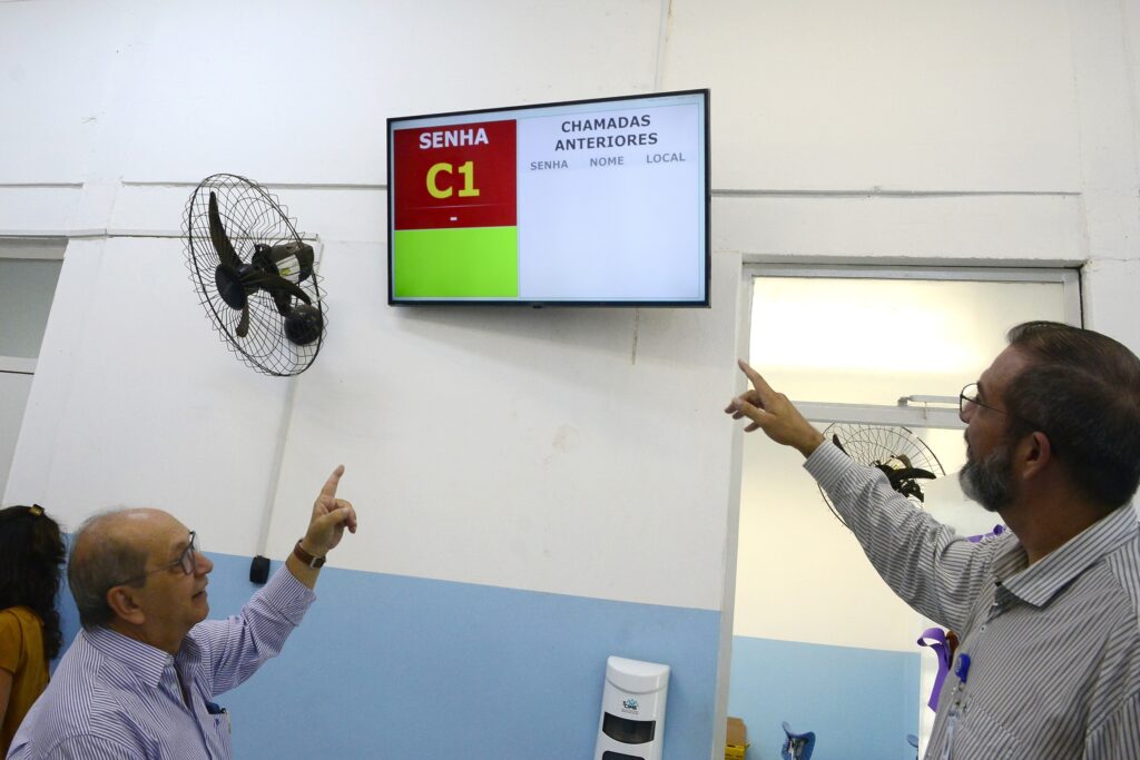 Após retirar senha no Totem, paciente é chamado por sinal visual e sonoro por monitor instalado na unidade