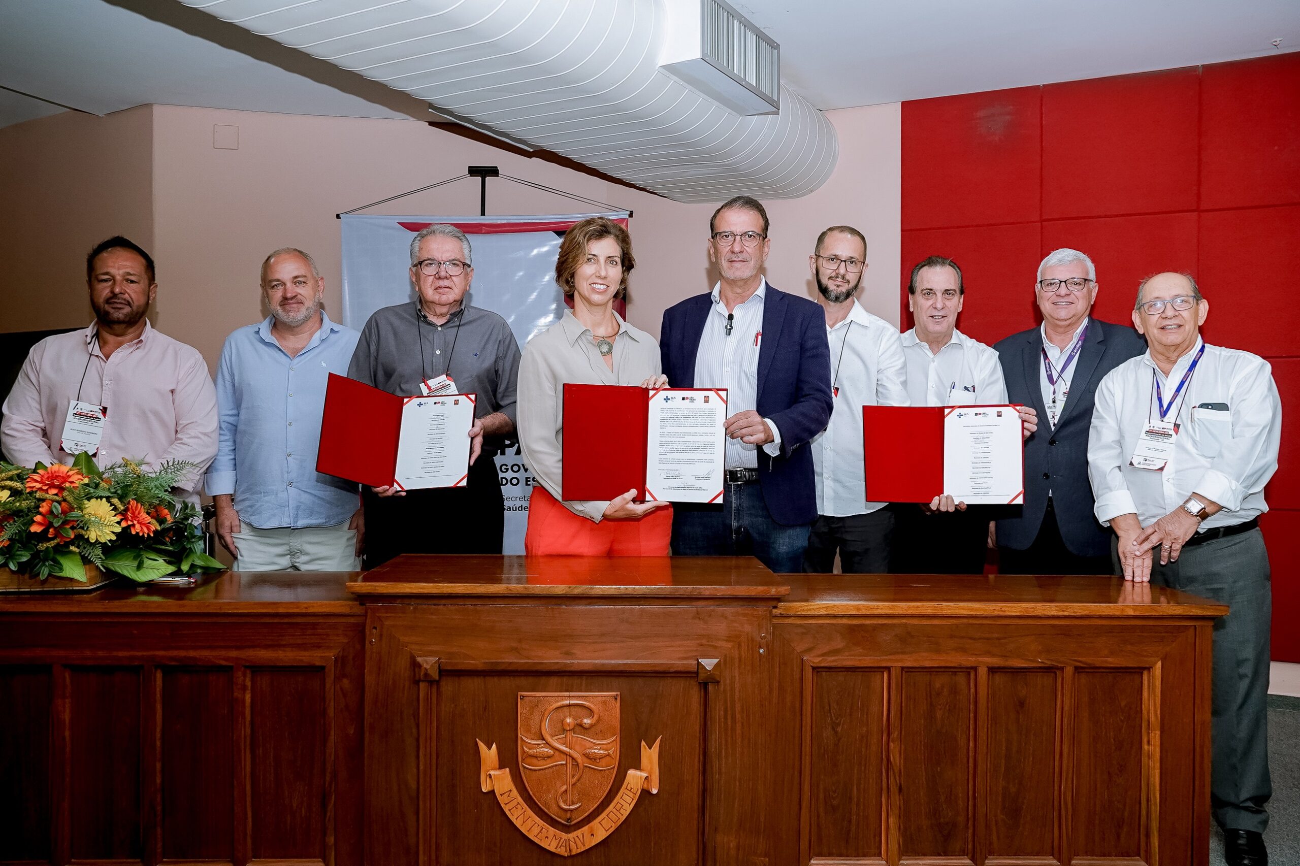Luciano Almeida e a secretária de estado em exercício, Priscilla Perdicaris, ao lado de representantes da RMP, OPAS e Cosems-SP após assinatura do termo de adesão