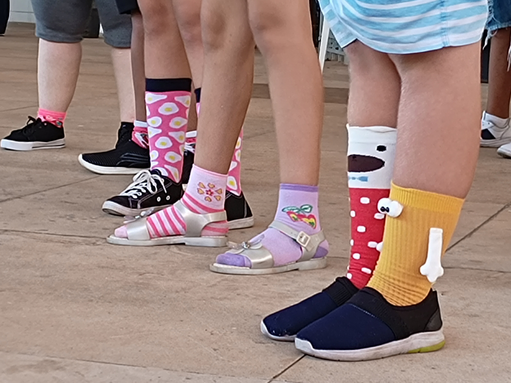 Na imagem, pés calçados de meias sem par, pela campanha Lots of Socks
