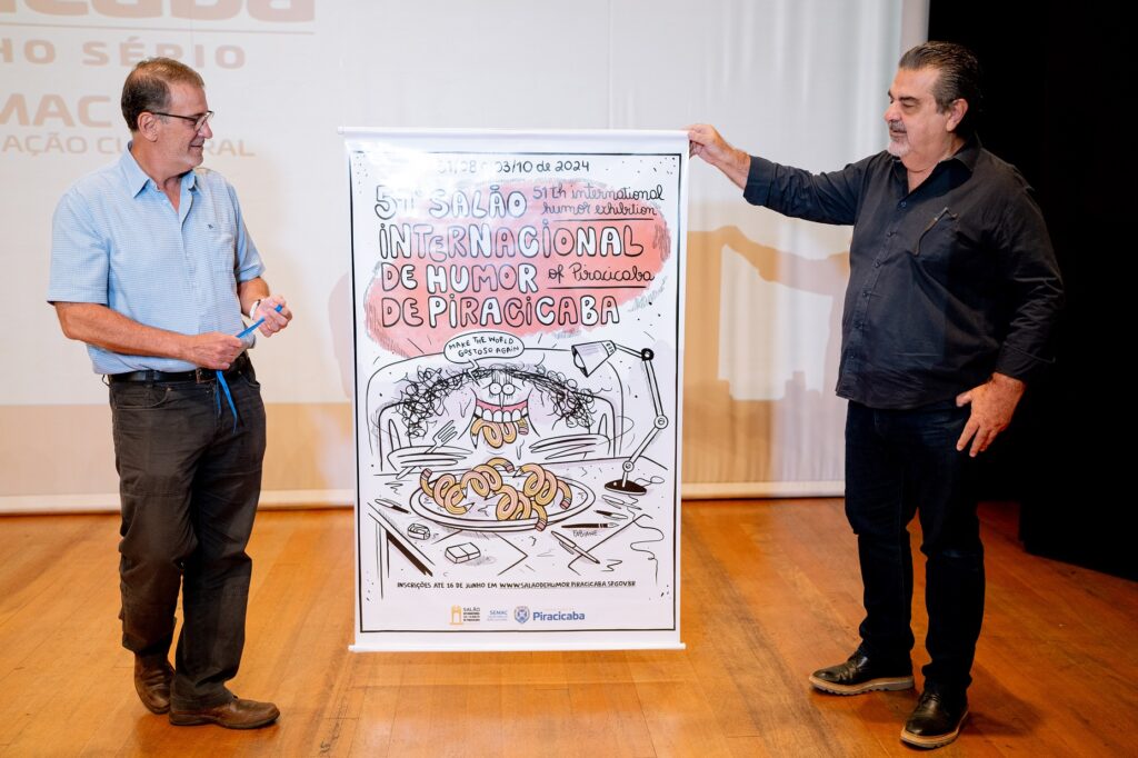 Prefeito Luciano e secretário Beltrame junto ao cartaz da 51 edicao do Salão de Humor