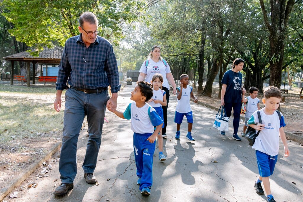 Prefeito Luciano Almeida camina com criança no zoológico.