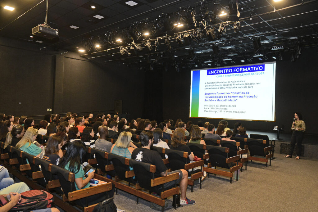 Público sentado assiste palestra no encontro formativo