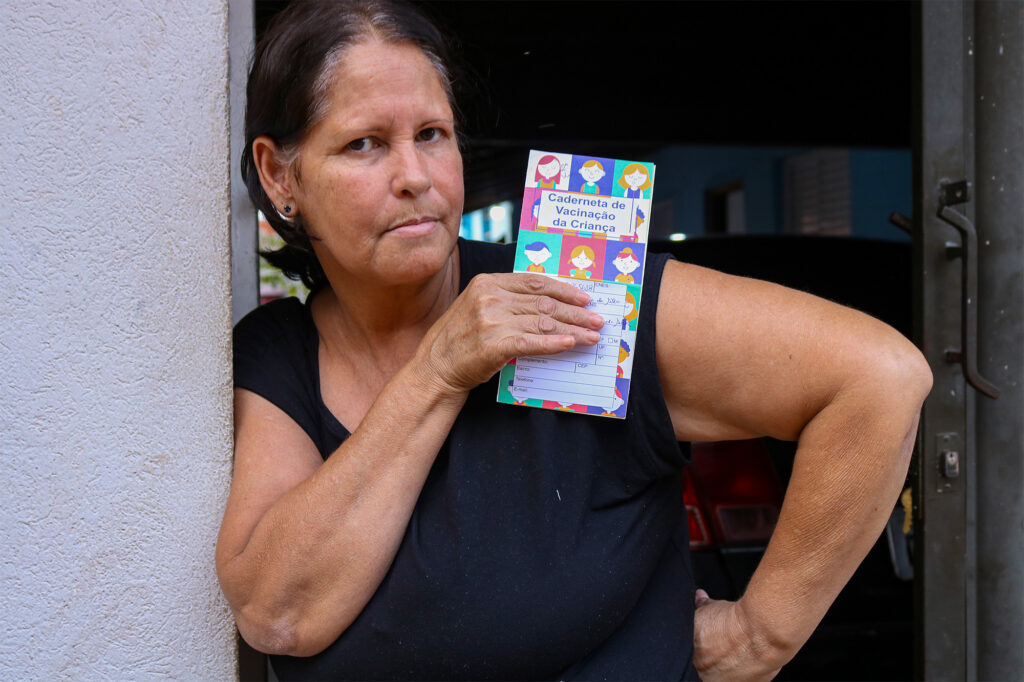 Raquel Godoy com a carteira de vacinação da pequena Laura, de 4 anos