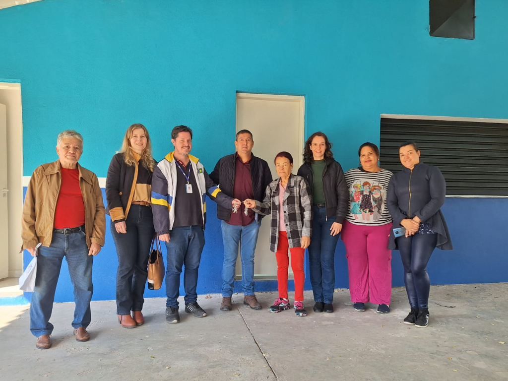 Membros da Associação em pé, recebendo as chaves do Centro comunitário