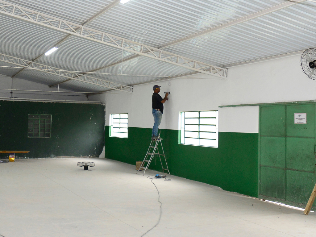 Trabalhador executa serviço na parte interna do Centro Comunitário