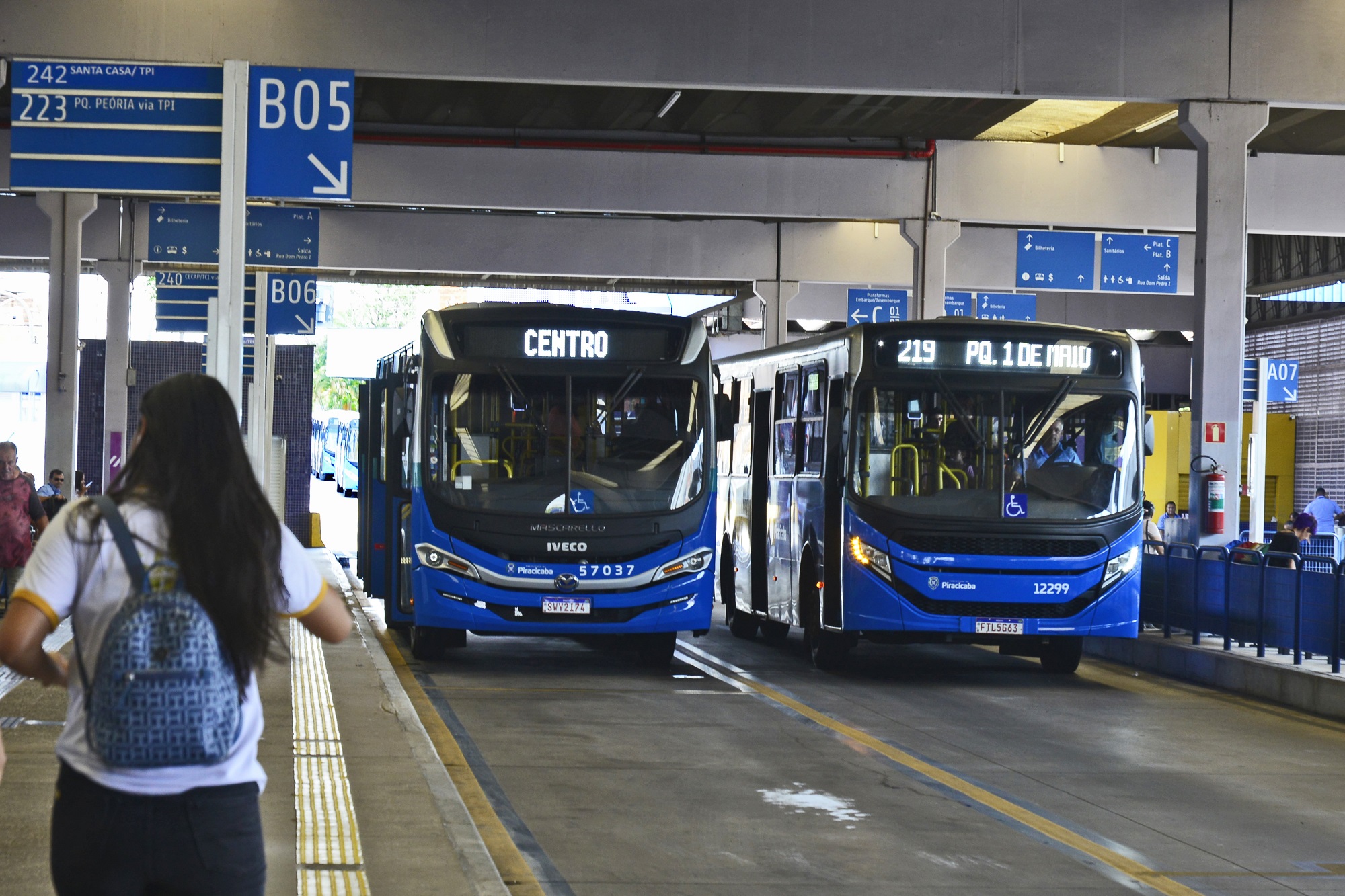 Dois ônibus na cor azul entrando no Terminal Central de Integração.
