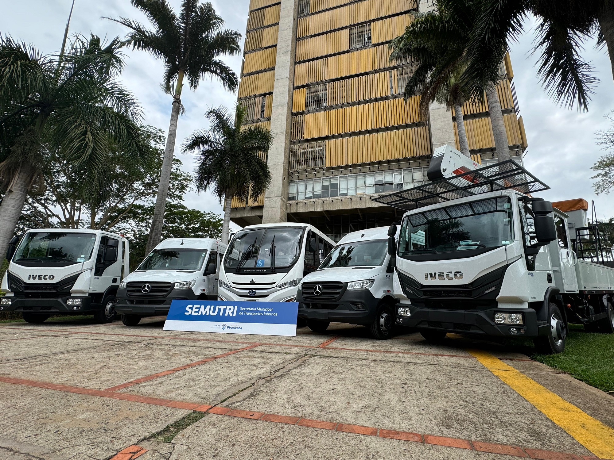Cinco veículos claros comdetalhes em preto, estacionados na rampa do Centro Cívico.