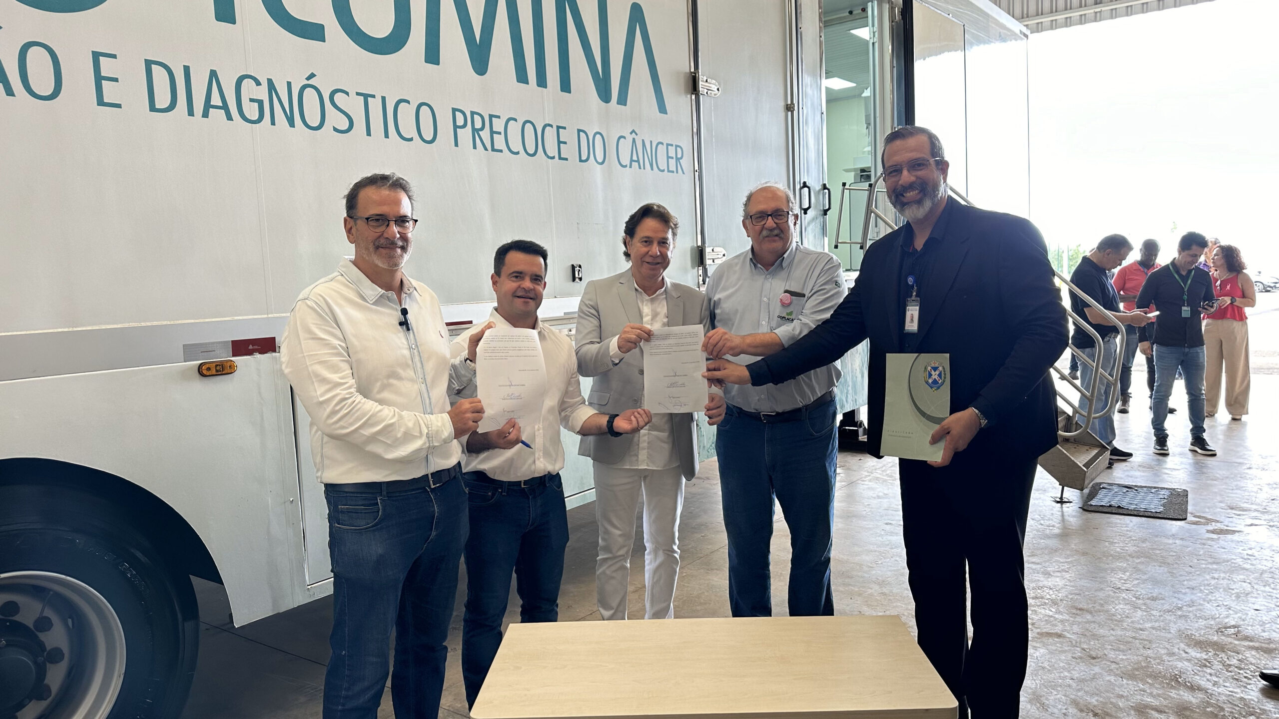 Imagem mostra o prefeito Luciano Almeida junto a demais autoridades com o documento oficial para a reabertura da Associação Ilumina