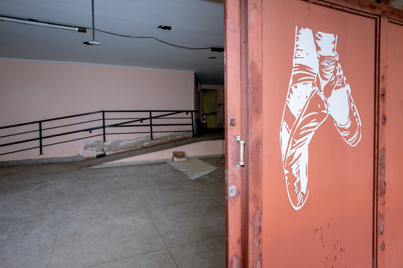 Porta semi-aberta de espaço dentro do teatro à frente da imagem