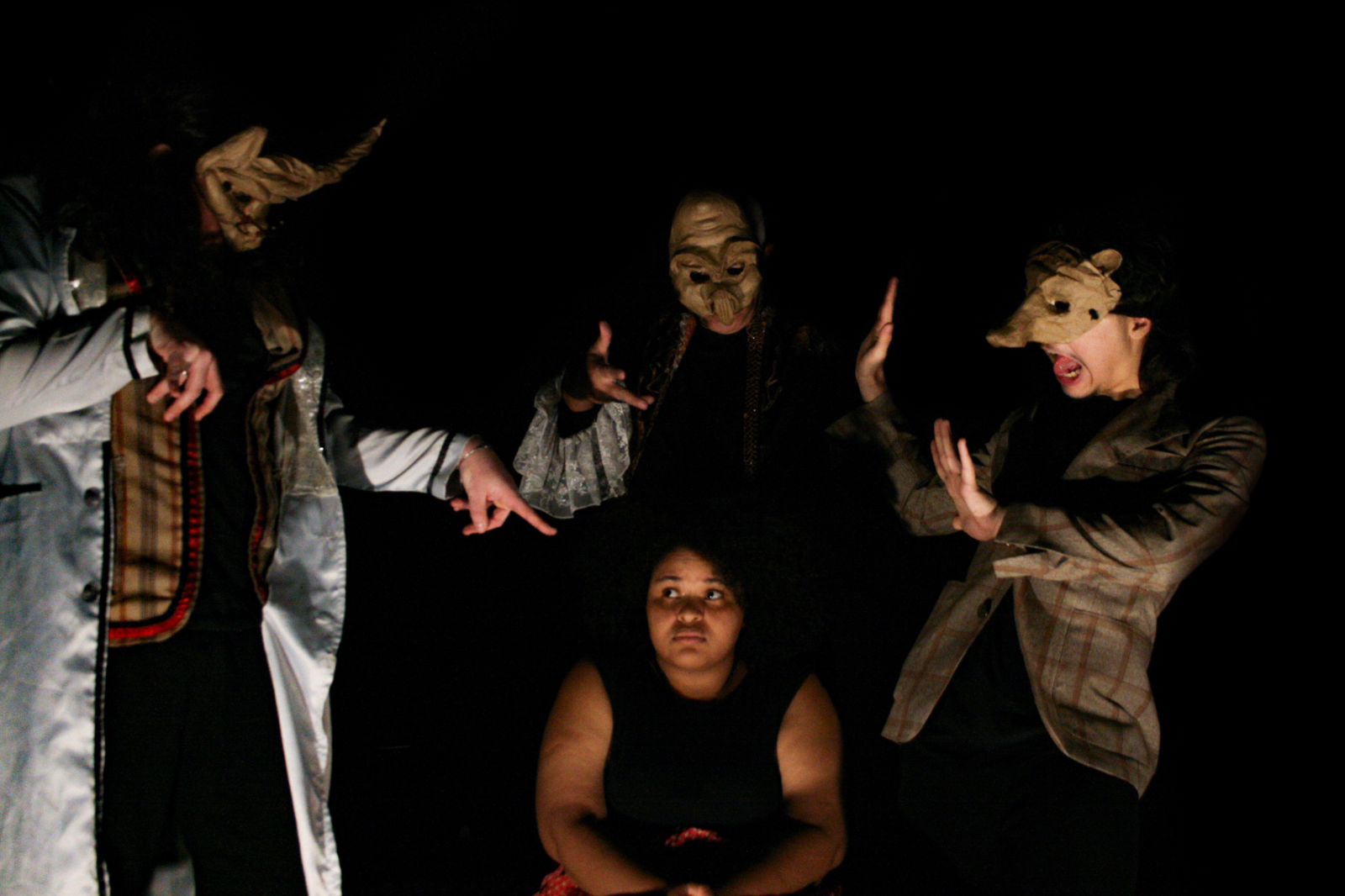 Atores da Ceta posam com figurino especial e máscaras em meio à penumbra