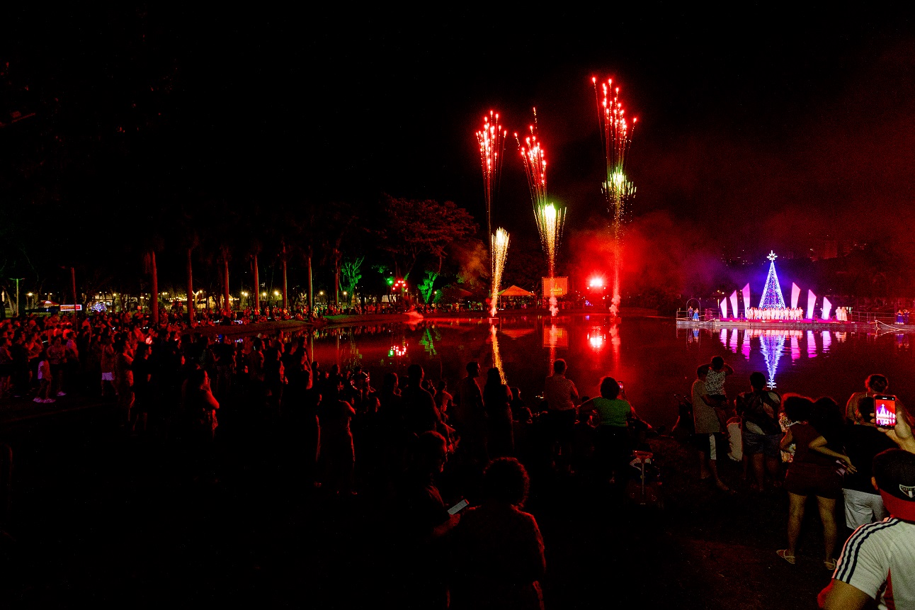 Em plano aberto, à noite, fogos de artifício e luzes formam espetáculo de Natal no Parque da Rua do Porto