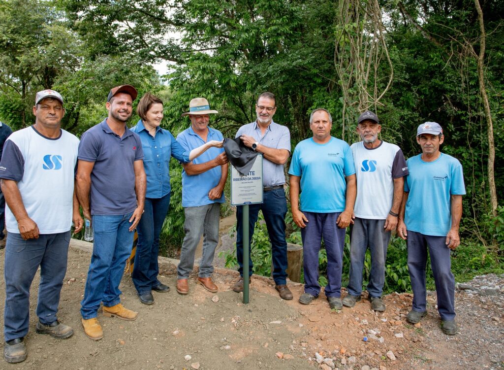 Prefeito Luciano Almeida e a secretaria Nancy Thame, ao lado de agricultores, decerram placa de restauração de ponte